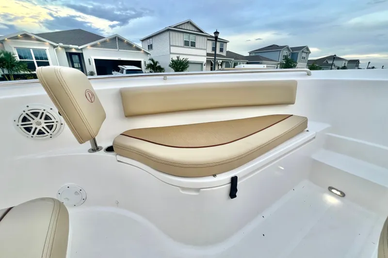 Slide: The Image of 2017 Pursuit C 238 Center Console boat interior with beige seating and speaker. - 64