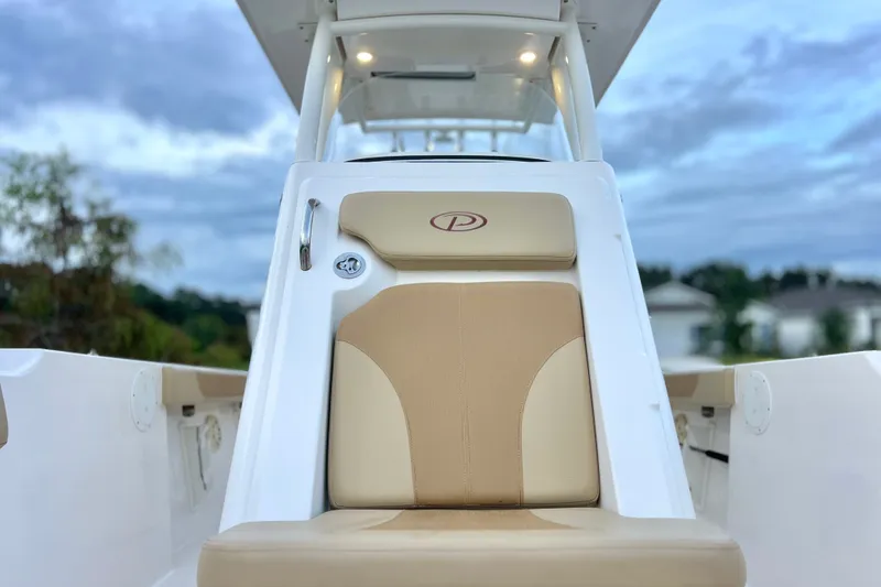 Slide: The Image of 2017 Pursuit C 238 Center Console boat seat with beige upholstery, outdoor setting. - 80