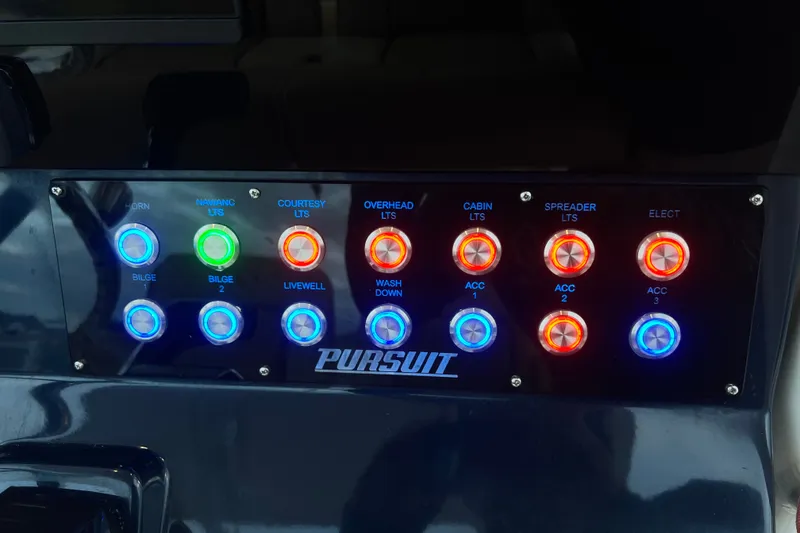 Slide: The Image of Control panel of a 2017 Pursuit C 238 Center Console boat with illuminated switches. - 76