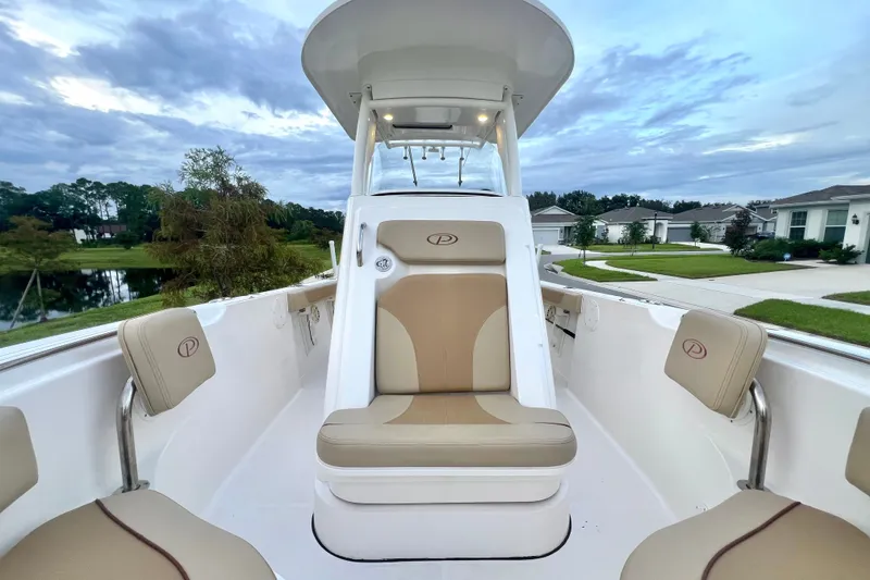 Slide: The Image of 2017 Pursuit C 238 Center Console boat interior with beige seating, under a cloudy sky. - 79