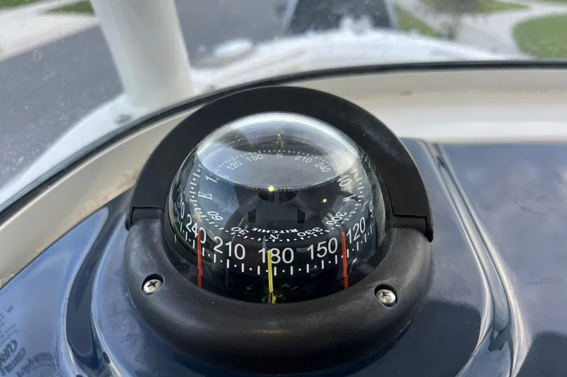Slide: The Image of Compass on 2017 Pursuit C 238 Center Console boat dashboard. - 56