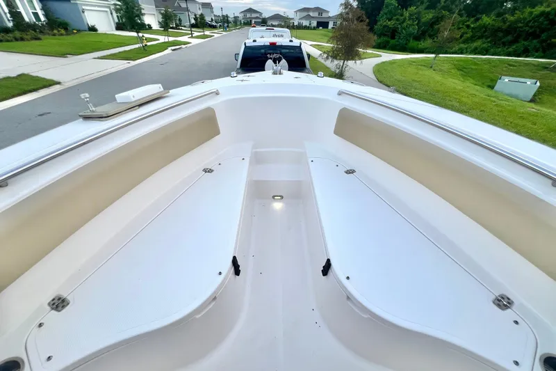 Slide: The Image of 2017 Pursuit C 238 Center Console boat interior with seating, parked on a residential street. - 69