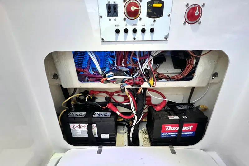 Slide: The Image of Electrical compartment of a 2017 Pursuit C 238 Center Console boat with batteries and wiring. - 91