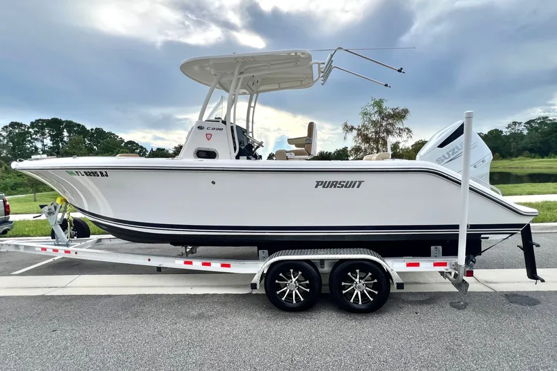 Slide: The Image of 2017 Pursuit C 238 Center Console boat on trailer, parked outdoors. - 15