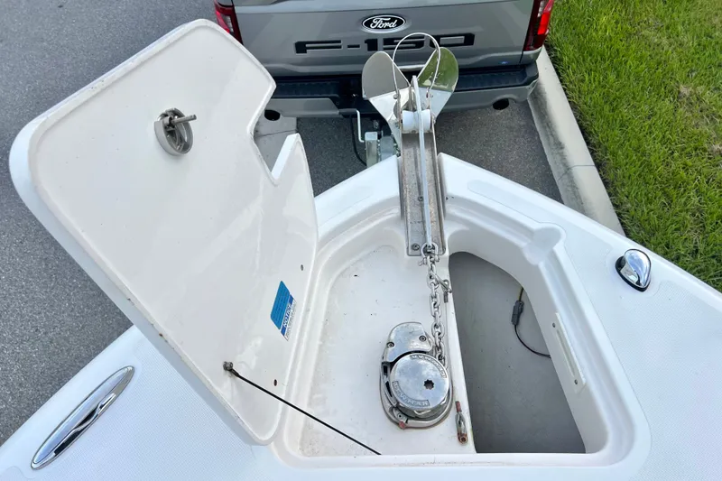 Slide: The Image of Open anchor compartment of 2017 Pursuit C 238 Center Console boat near a Ford F-150 truck. - 66