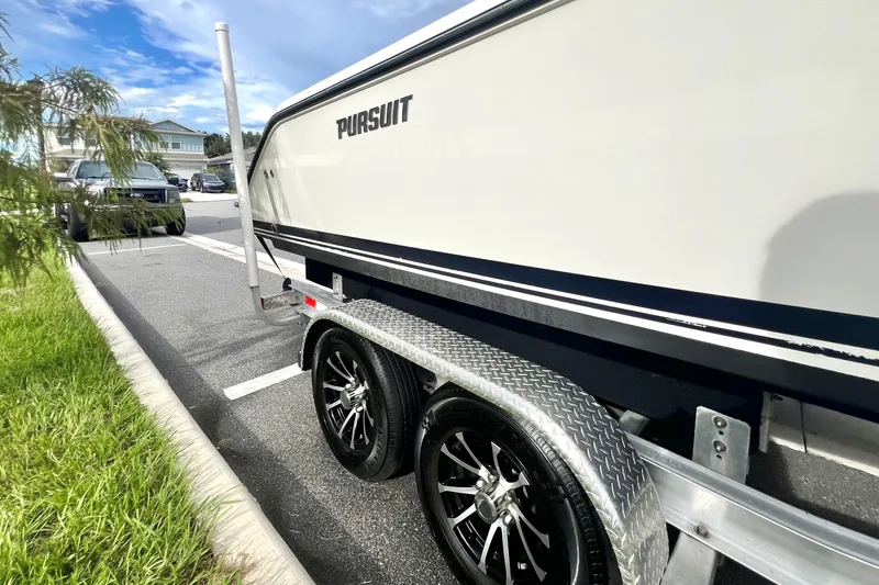 Slide: The Image of 2017 Pursuit C 238 Center Console boat on trailer, parked in sunny lot. - 2