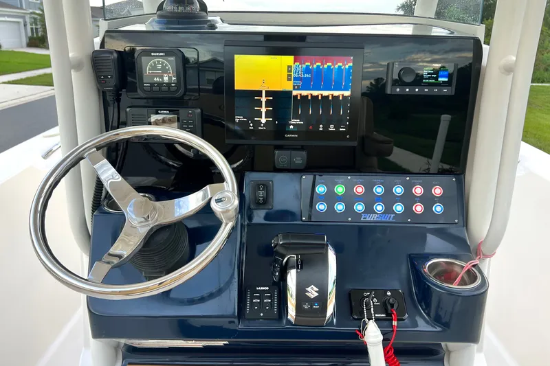 Slide: The Image of La imagen muestra el timón de un barco Pursuit C 238 Center Console de 2017. Presenta un sistema de navegación moderno, volante de acero inoxidable y varios controles. - 43