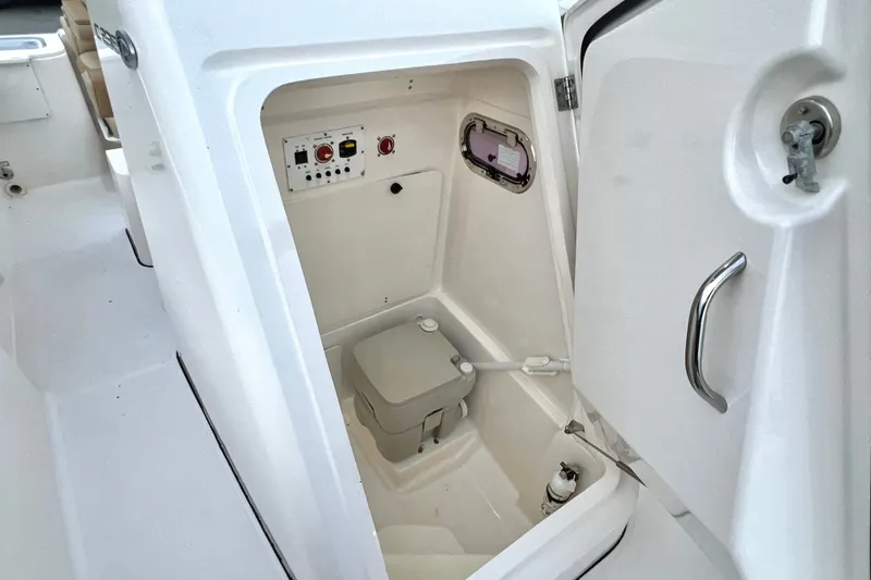 Slide: The Image of 2017 Pursuit C 238 Center Console boat interior with compact marine toilet. - 84