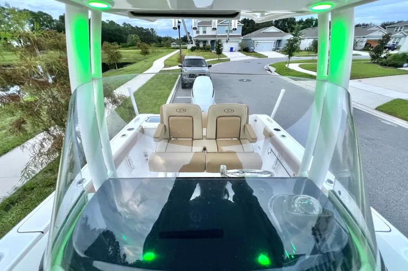 Slide: The Image of 2017 Pursuit C 238 Center Console boat with green LED lights on a suburban street. - 41