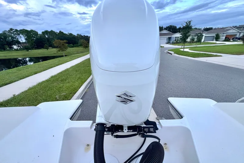 Slide: The Image of 2017 Pursuit C 238 Center Console boat with Suzuki outboard motor on a suburban street. - 28