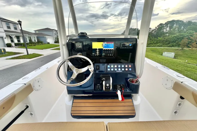 Slide: The Image of 2017 Pursuit C 238 Center Console boat dashboard with steering wheel and controls. - 44