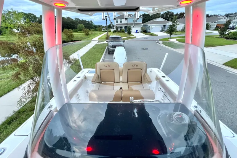 Slide: The Image of 2017 Pursuit C 238 Center Console boat on suburban street, featuring sleek design and seating. - 40