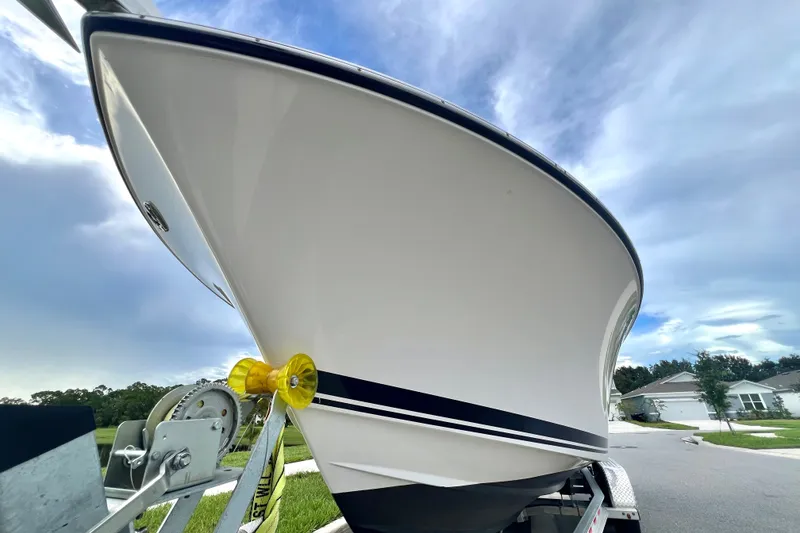 Slide: The Image of 2017 Pursuit C 238 Center Console boat on trailer under cloudy sky. - 17