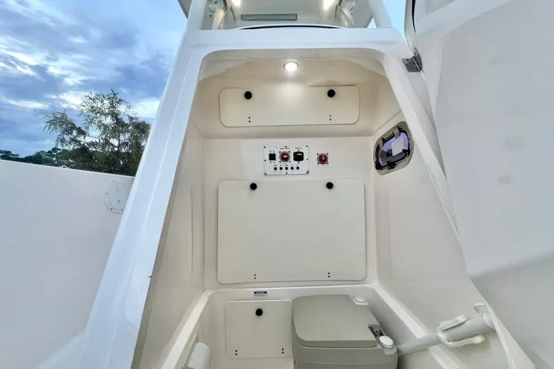 Slide: The Image of 2017 Pursuit C 238 Center Console interior with control panel and portable toilet. - 81