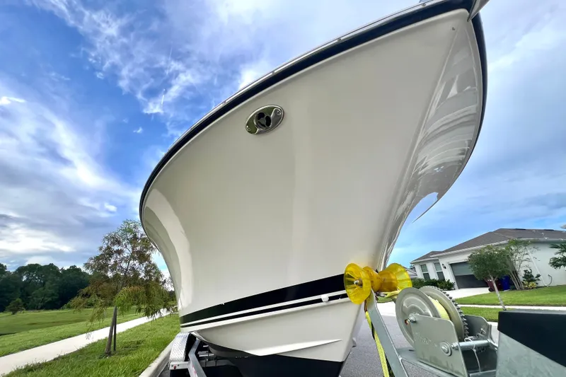 Slide: The Image of 2017 Pursuit C 238 Center Console boat on trailer, blue sky background. - 19