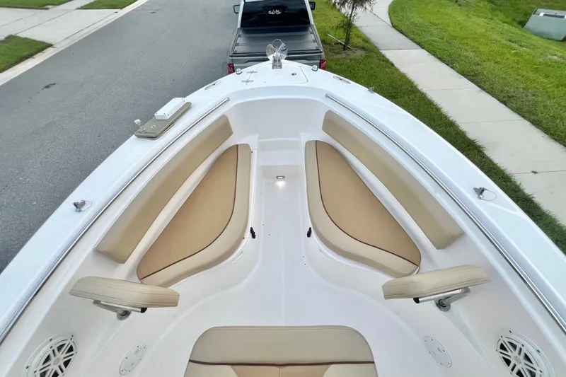 Slide: The Image of 2017 Pursuit C 238 Center Console boat with beige seating, parked on a street. - 67