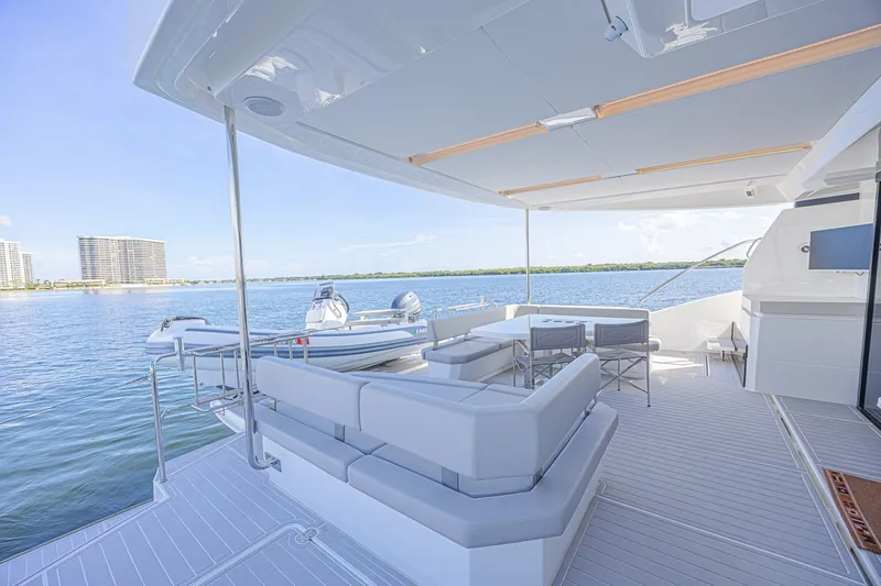 Slide: The Image of Luxurious 2025 Leopard 53 Powercat yacht deck with seating, overlooking serene waterfront. - 13