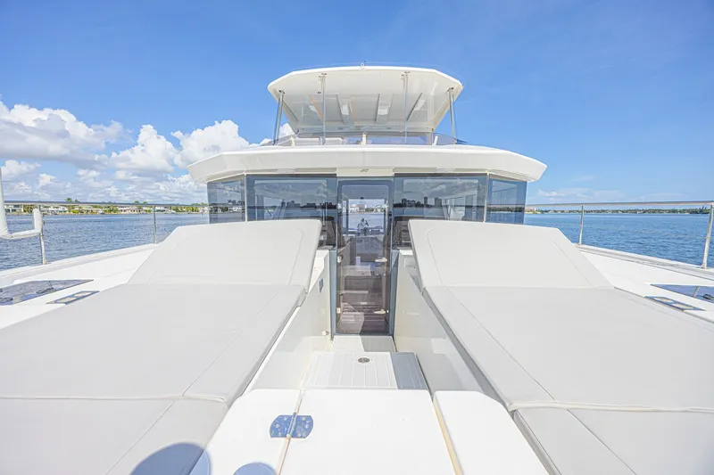 Slide: The Image of 2025 Leopard 53 Powercat yacht deck with sun loungers, ocean view, and clear blue sky. - 16