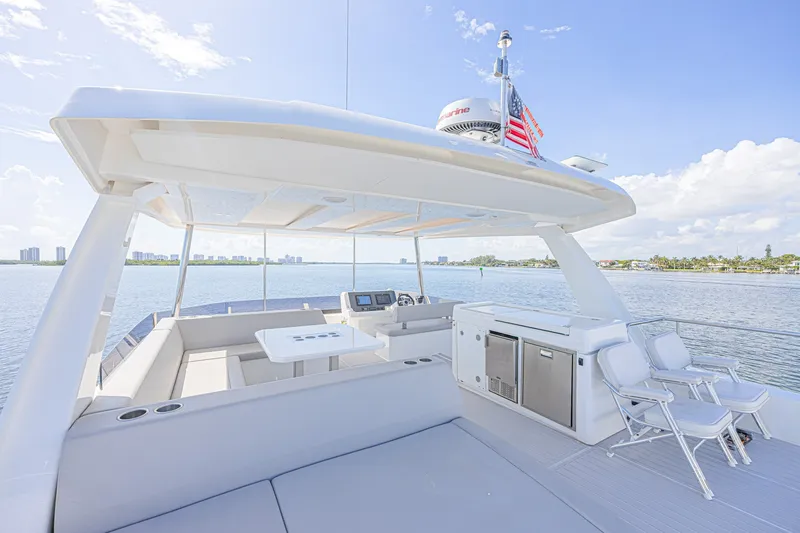 Slide: The Image of 2025 Leopard 53 Powercat yacht deck with seating, table, and ocean view. - 18