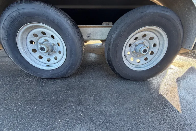 Slide: The Image of Trailer wheels for 2017 Robalo R265 Walkaround boat on asphalt surface. - 64