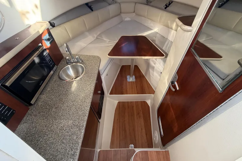 Slide: The Image of 2017 Robalo R265 Walkaround cabin interior with kitchenette, sink, and seating area. - 37