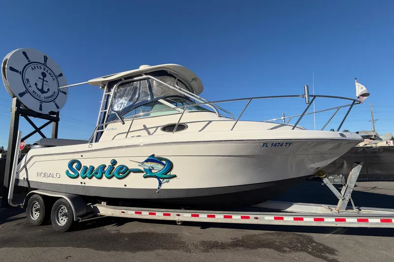 The Image of 2017 Robalo R265 Walkaround boat on trailer, named "Susie-Q," at a dealership. - 0