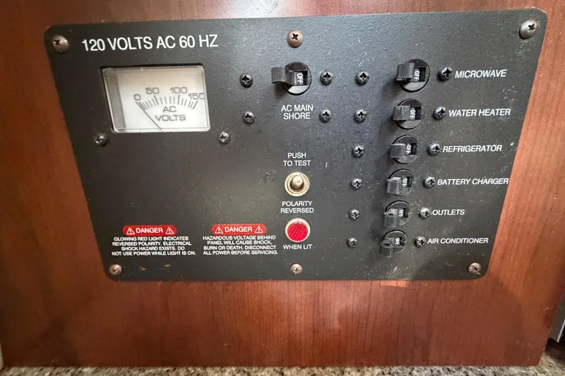 Slide: The Image of Electrical control panel on a 2017 Robalo R265 Walkaround boat, featuring various switches and voltage meter. - 46