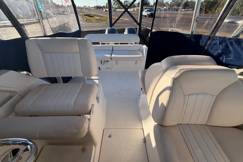Slide: The Image of 2017 Robalo R265 Walkaround boat interior with cushioned seating and clear canopy. - 55