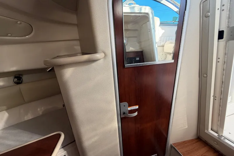 Slide: The Image of 2017 Robalo R265 Walkaround cabin interior with wooden door and seating area. - 41