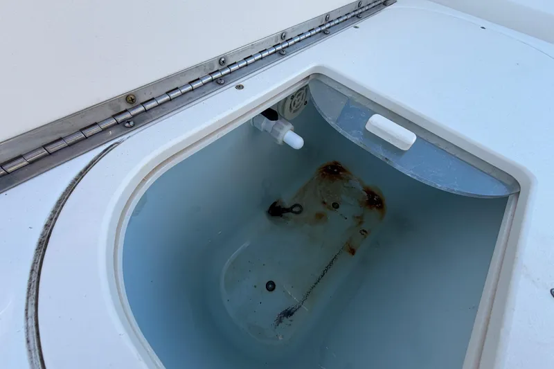 Slide: The Image of Livewell compartment on a 2017 Robalo R265 Walkaround boat, showing water and rust stains. - 63