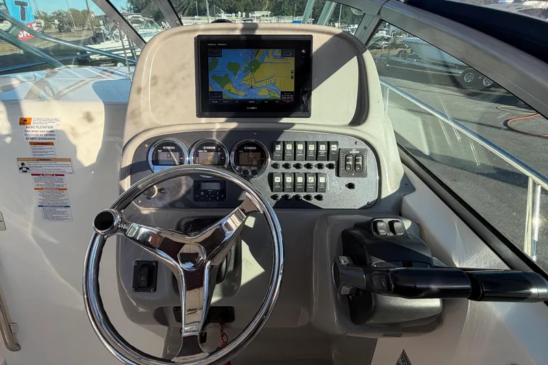 Slide: The Image of 2017 Robalo R265 Walkaround helm with steering wheel, navigation display, and control panel. - 28