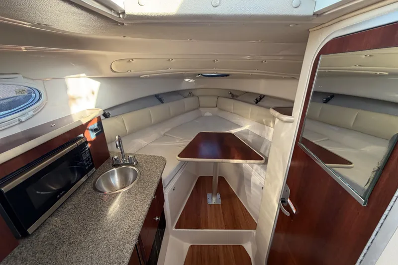 Slide: The Image of 2017 Robalo R265 Walkaround cabin interior with kitchenette, sink, and seating area. - 38