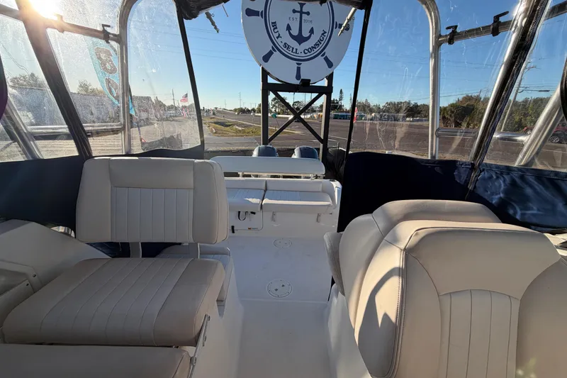 Slide: The Image of 2017 Robalo R265 Walkaround boat interior with cushioned seating and clear canopy. - 54
