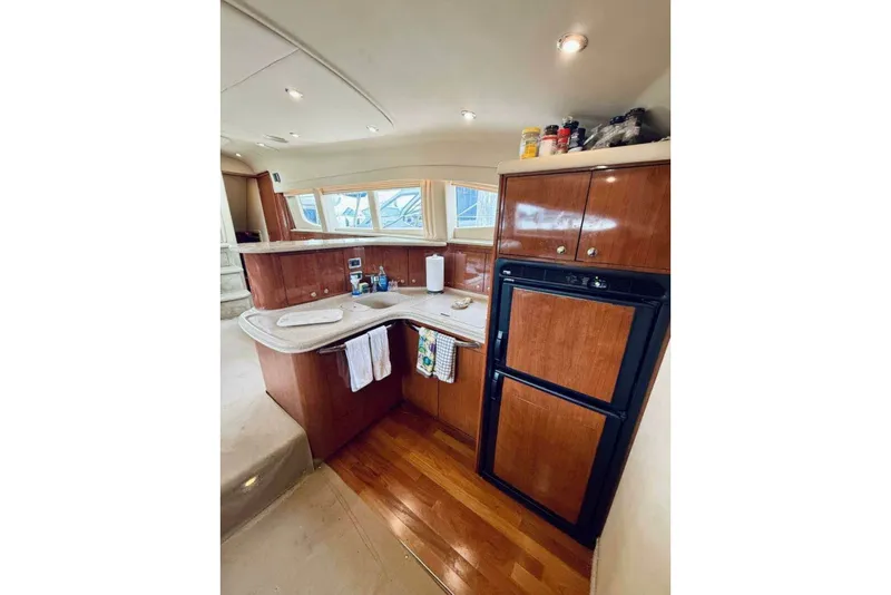 Slide: The Image of Interior of 2003 Sea Ray 480 Motor Yacht kitchen with wood cabinetry and modern appliances. - 21