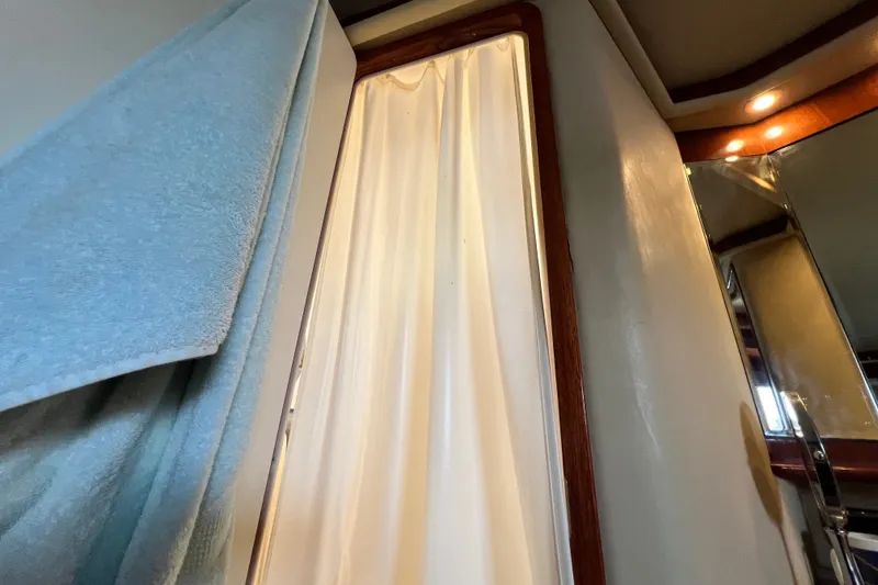 Slide: The Image of Interior of 2003 Sea Ray 480 Motor Yacht bathroom with shower curtain and towel. - 137