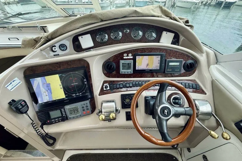 Slide: The Image of 2003 Sea Ray 480 Motor Yacht helm with navigation equipment and wooden steering wheel. - 17