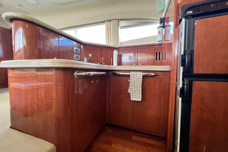 Slide: The Image of 2003 Sea Ray 480 Motor Yacht kitchen with wood cabinetry and modern appliances. - 127
