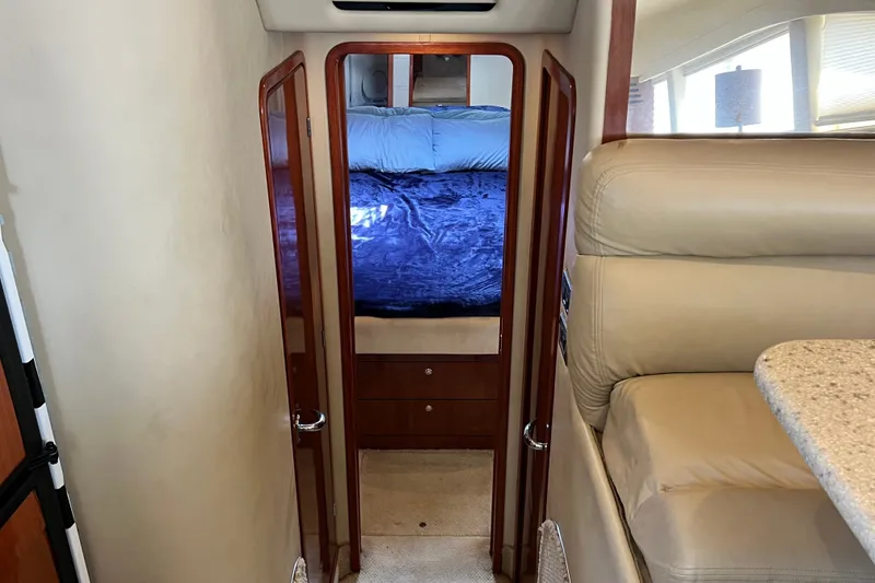 Slide: The Image of Interior view of a 2003 Sea Ray 480 Motor Yacht bedroom with plush bedding and wooden accents. - 101