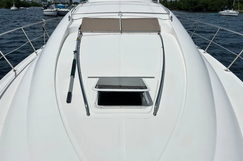 Slide: The Image of 2003 Sea Ray 480 Motor Yacht deck with open hatch, docked on calm water. - 73