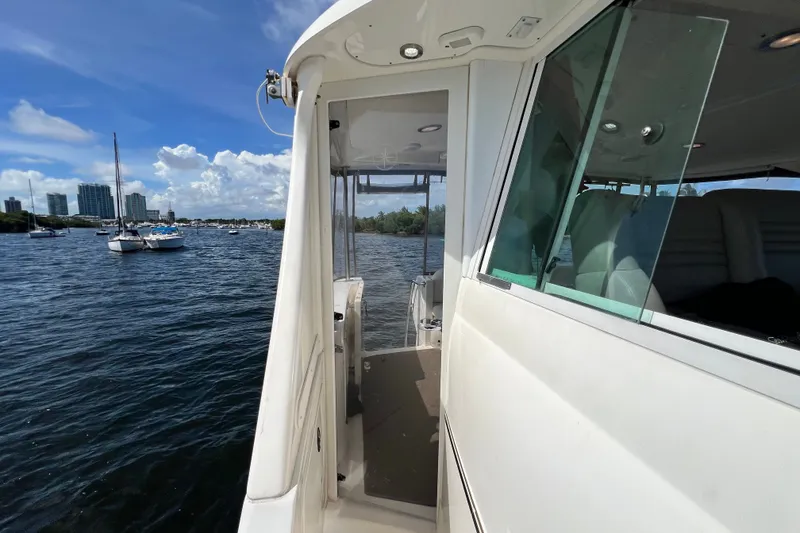 Slide: The Image of 2003 Sea Ray 480 Motor Yacht on water, with city skyline and sailboats in background. - 190