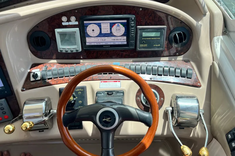Slide: The Image of 2003 Sea Ray 480 Motor Yacht helm with steering wheel, controls, and navigation instruments. - 86