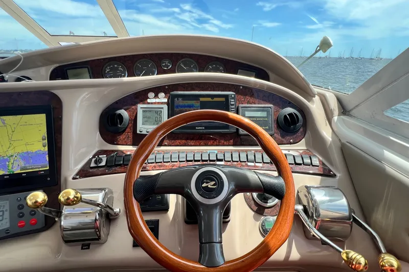 Slide: The Image of 2003 Sea Ray 480 Motor Yacht helm with navigation instruments and wooden steering wheel. - 96