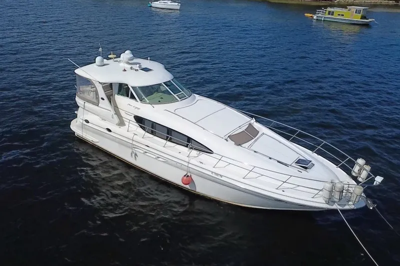 Slide: The Image of 2003 Sea Ray 480 Motor Yacht on calm water, showcasing sleek design and spacious deck. - 14