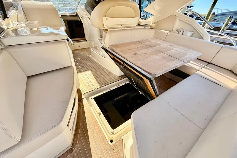 Slide: The Image of 2016 Cranchi M44 HT yacht interior with beige seating and wooden table. - 17
