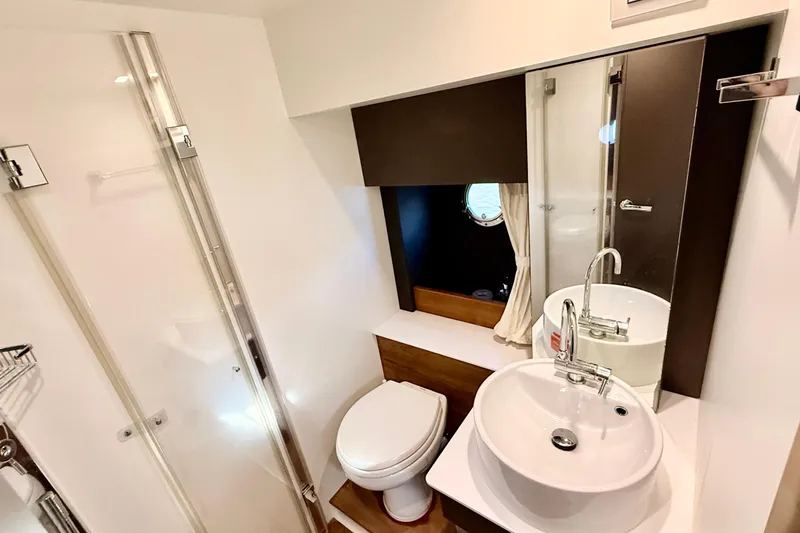Slide: The Image of Modern bathroom in 2016 Cranchi M44 HT yacht, featuring sleek fixtures and a porthole window. - 106