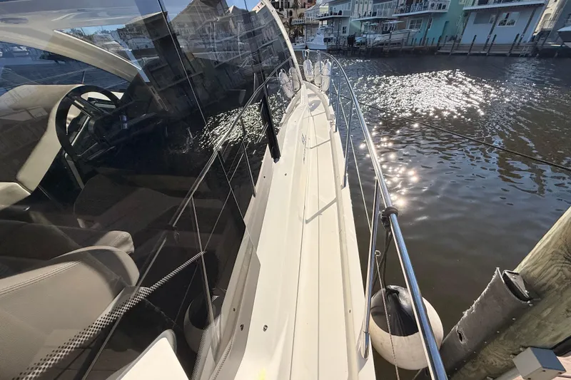 Slide: The Image of 2016 Cranchi M44 HT yacht docked, reflecting sunlight on water. - 145