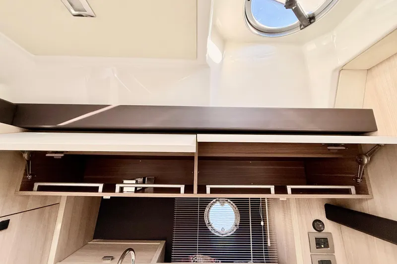 Slide: The Image of Interior view of 2016 Cranchi M44 HT yacht, featuring sleek cabinetry and a porthole window. - 57