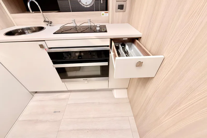 Slide: The Image of Modern kitchen in 2016 Cranchi M44 HT yacht with stove, sink, and open drawer. - 60