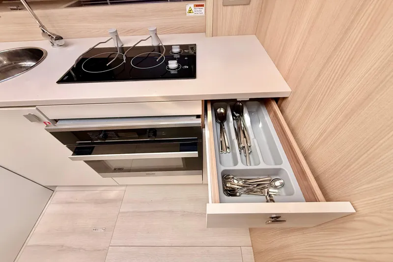 Slide: The Image of Modern kitchen in 2016 Cranchi M44 HT yacht with stove, oven, and open cutlery drawer. - 61