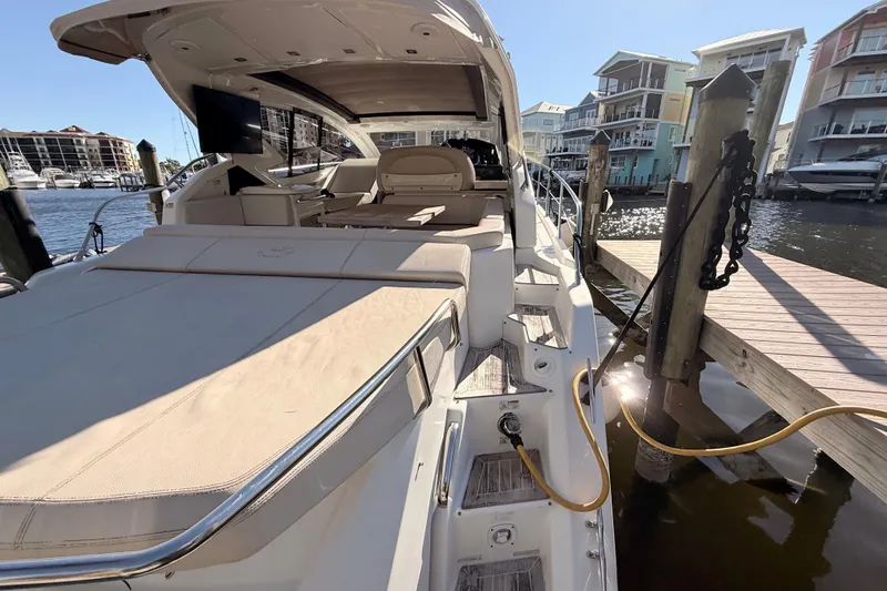 Slide: The Image of 2016 Cranchi M44 HT yacht docked at marina, showcasing luxurious deck and seating area. - 141